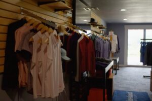 Golf shop interior with neatly arranged shirts on hangers, showcasing a variety of colors and styles.